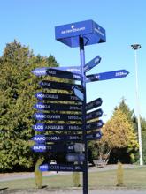 signpost with arrows pointing to different destinations in many directions