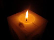 photo of a square candle burning in the dark